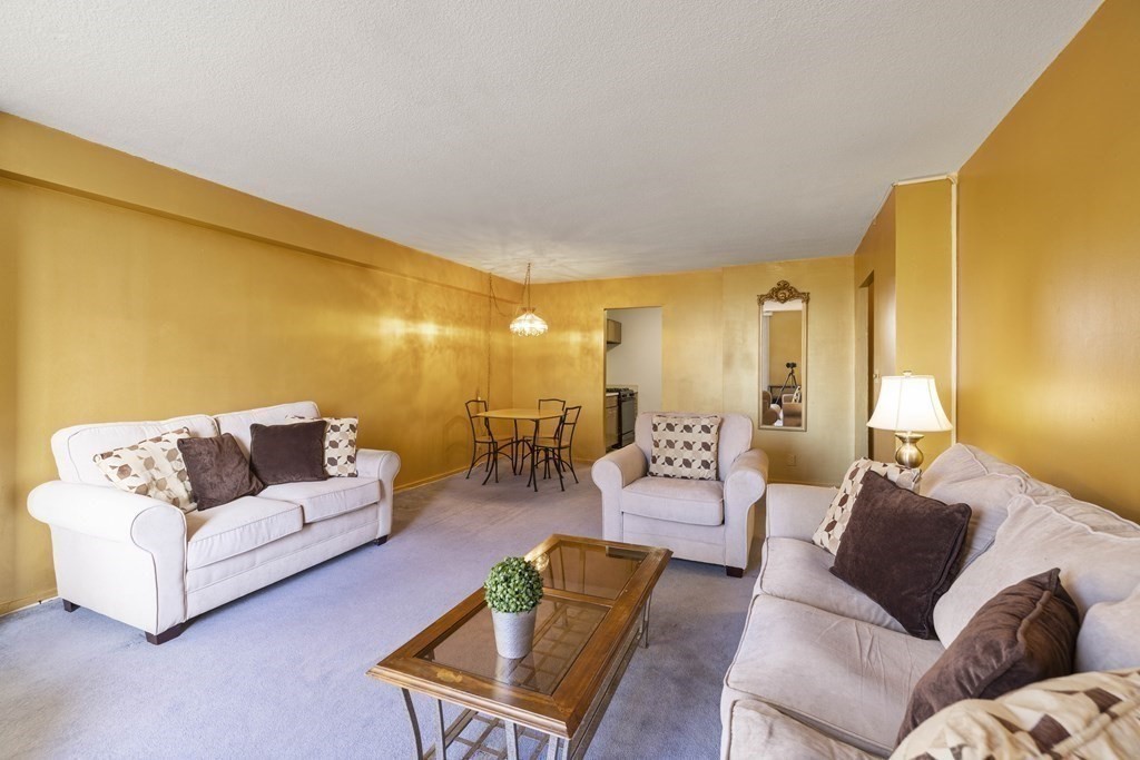 33 Pond Avenue, Unit 912 Brookline, MA 02445 - Photo 3 of 17 a living room with furniture and a large window