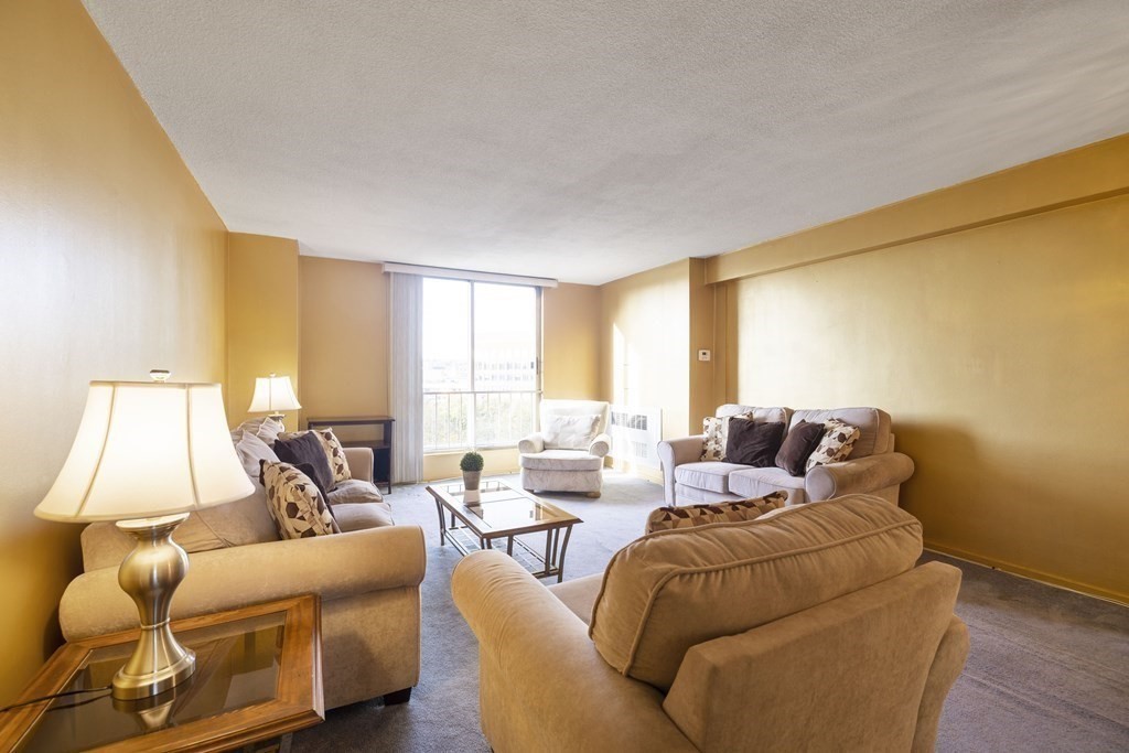33 Pond Avenue, Unit 912 Brookline, MA 02445 - Photo 4 of 17 a living room with furniture and a large window