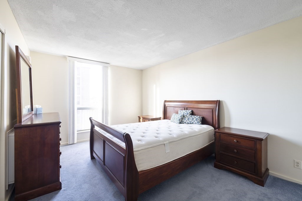 33 Pond Avenue, Unit 912 Brookline, MA 02445 - Photo 6 of 17 a bedroom with a bed and a dresser