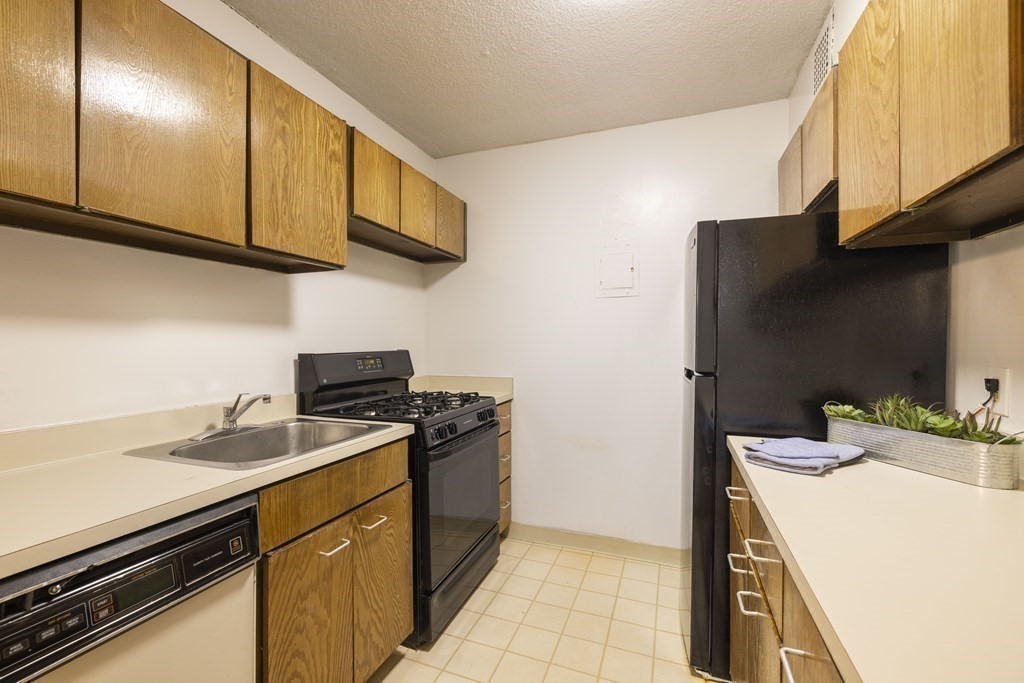 33 Pond Avenue, Unit 912 Brookline, MA 02445 - Photo 7 of 17 a kitchen with stainless steel appliances a sink a stove and cabinets