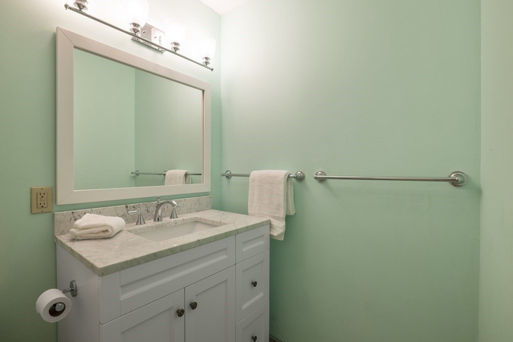 33 Pond Avenue, Unit 912 Brookline, MA 02445 - Photo 8 of 17 a bathroom with a sink and a mirror