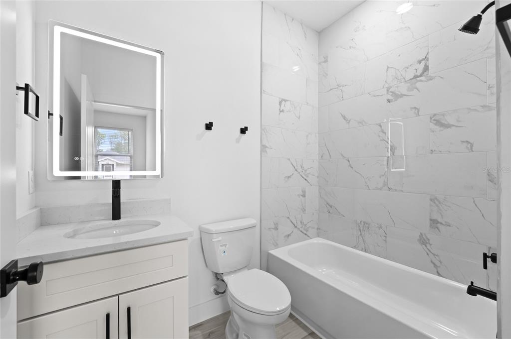 4450 Badali Road North Port, FL 34286 - Photo 11 of 28 a bathroom with a toilet sink vanity tub and shower