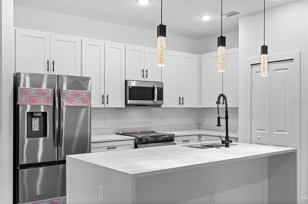 4450 Badali Road North Port, FL 34286 - Photo 5 of 28 a kitchen with stainless steel appliances a refrigerator sink and white cabinets