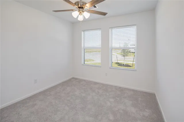 an empty room with a window and a fan