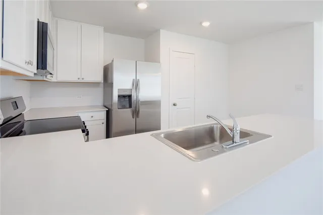 a kitchen with stainless steel appliances a refrigerator sink and cabinets