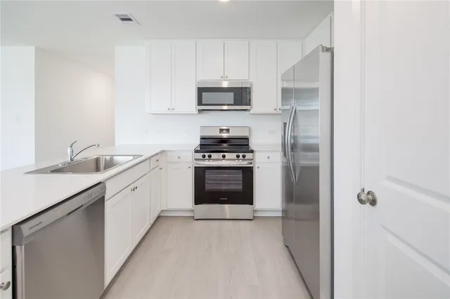 a kitchen with granite countertop a stove and a refrigerator