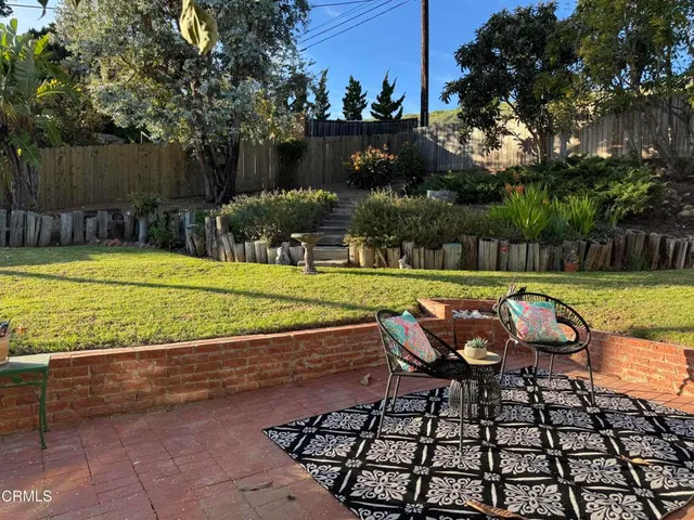 a view of a swimming pool with a patio and a yard