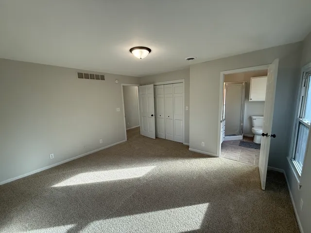 a bathroom with a granite countertop sink toilet and mirror