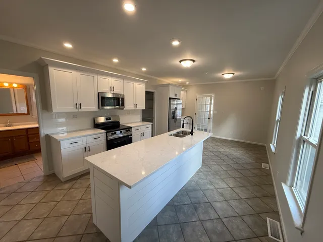 a large kitchen with a large counter top appliances and cabinets