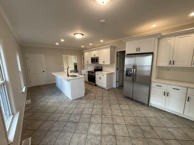 a kitchen with stainless steel appliances granite countertop a refrigerator sink and cabinets