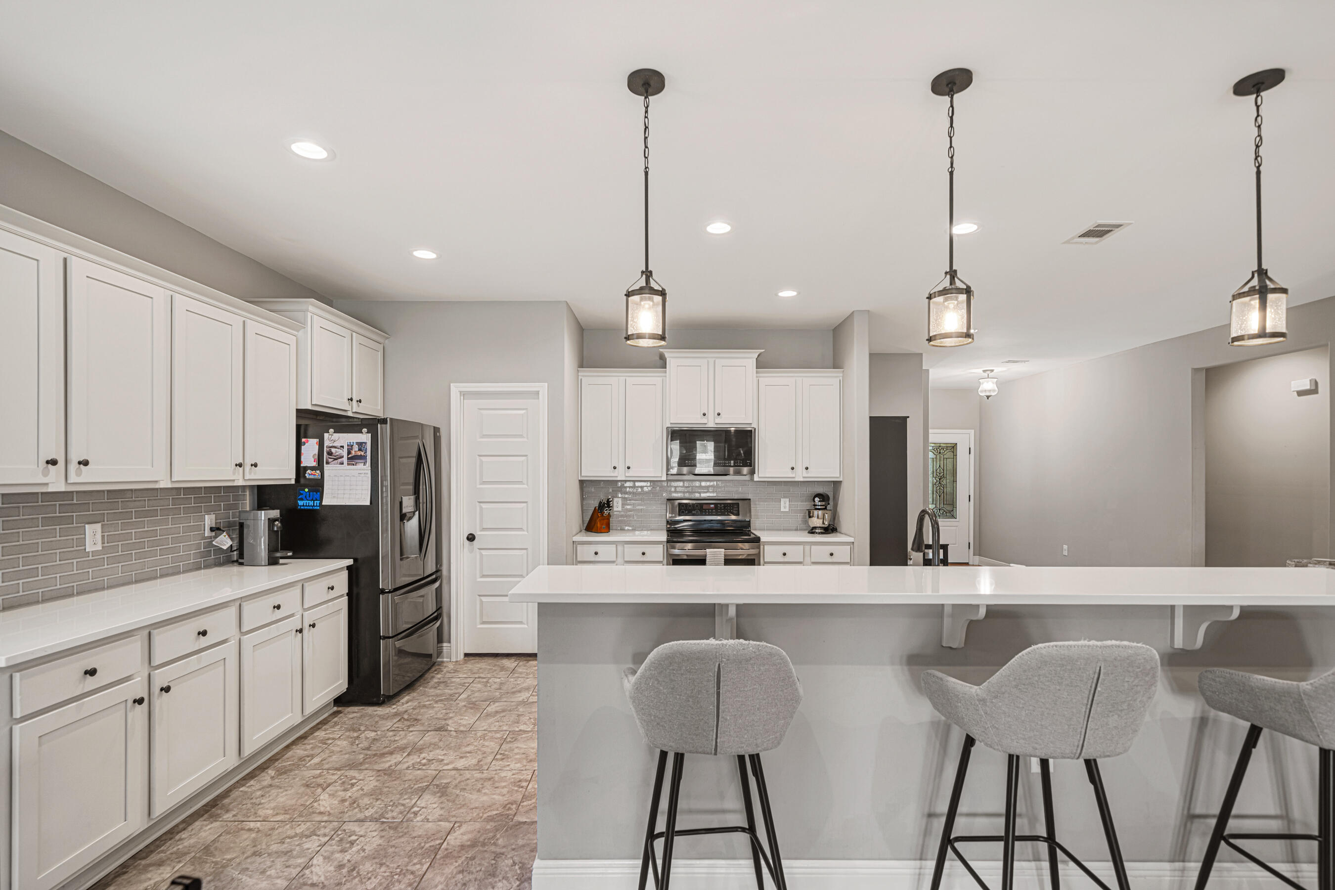 801 Playground Road Fort Walton Beach, FL 32547 - Photo 7 of 38 a kitchen with stainless steel appliances kitchen island granite countertop a sink a stove a refrigerator and cabinets