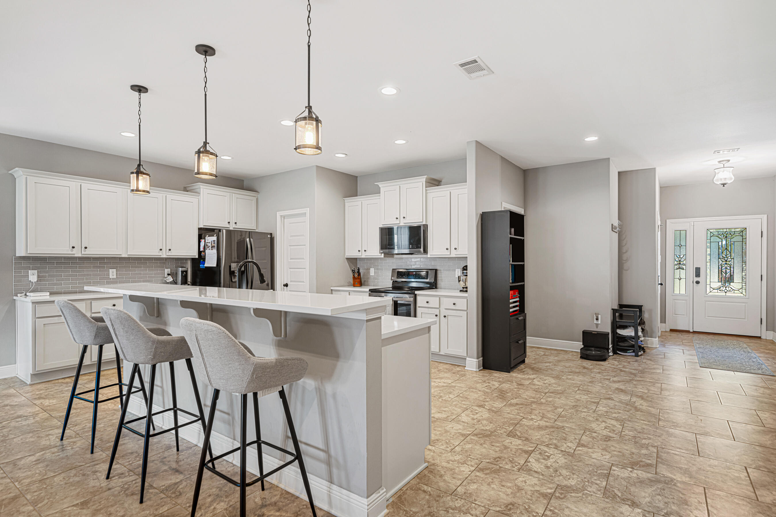 801 Playground Road Fort Walton Beach, FL 32547 - Photo 9 of 38 a kitchen with stainless steel appliances kitchen island granite countertop a stove a refrigerator a oven a sink a island with a dining table and chairs