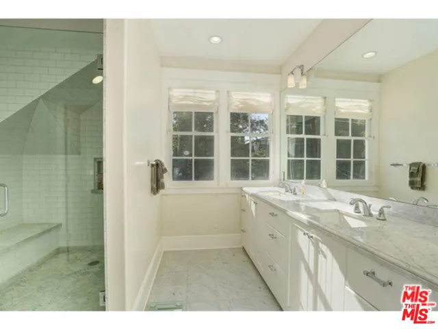 a bathroom with a granite countertop sink mirror and a bath tub
