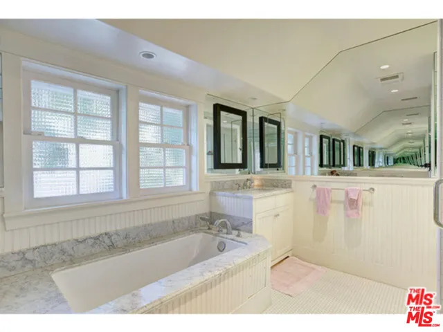 a bathroom with a bathtub sink and mirror