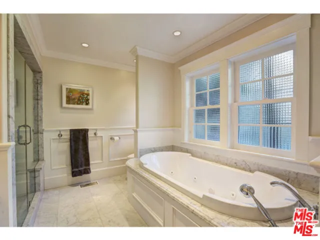 a bathroom with a tub a sink and a large mirror