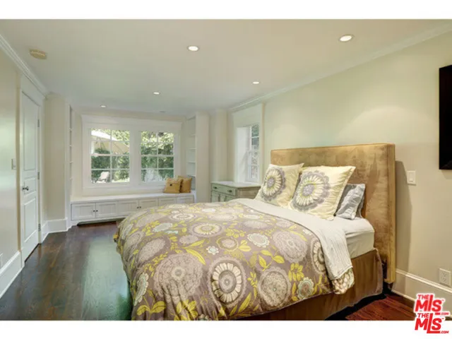 a bedroom with a bed and a large window