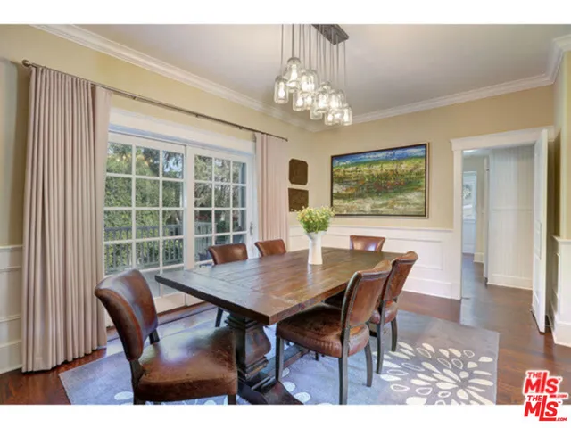 a view of a dining room with furniture a chandelier and wooden floor