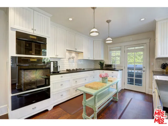 a kitchen with a stove a microwave a sink and cabinets