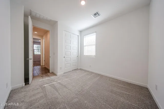 an empty room with windows and closet