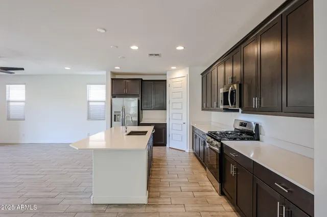a kitchen with stainless steel appliances granite countertop a sink stove and refrigerator