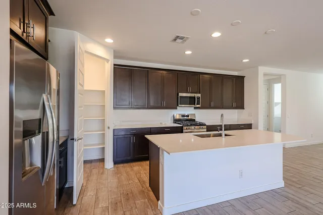 a kitchen with stainless steel appliances granite countertop a sink stove refrigerator and cabinets
