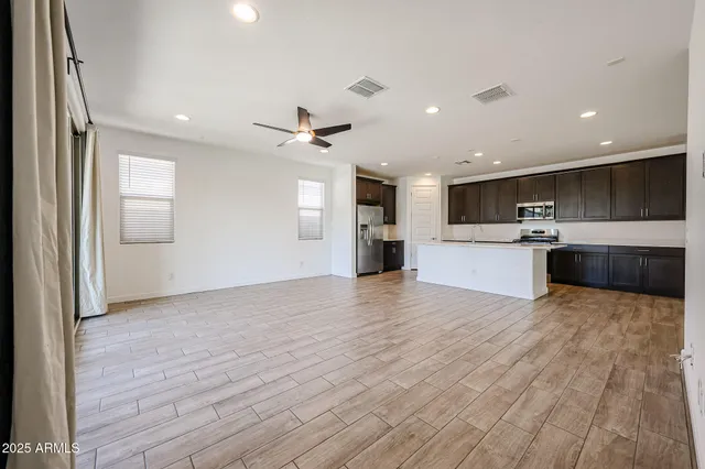 a view of kitchen with kitchen island a sink stainless steel appliances and cabinets