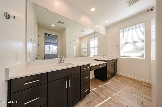 a spacious bathroom with a granite countertop sink a mirror and a bathtub