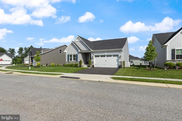 a view of a house with a big yard and large trees