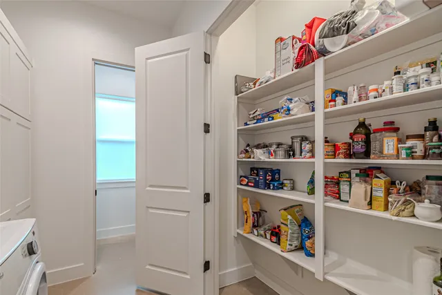 a utility room with lots of white furniture and a shower
