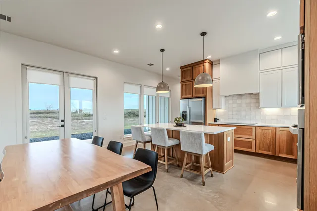 a kitchen with a table chairs stainless steel appliances and cabinets