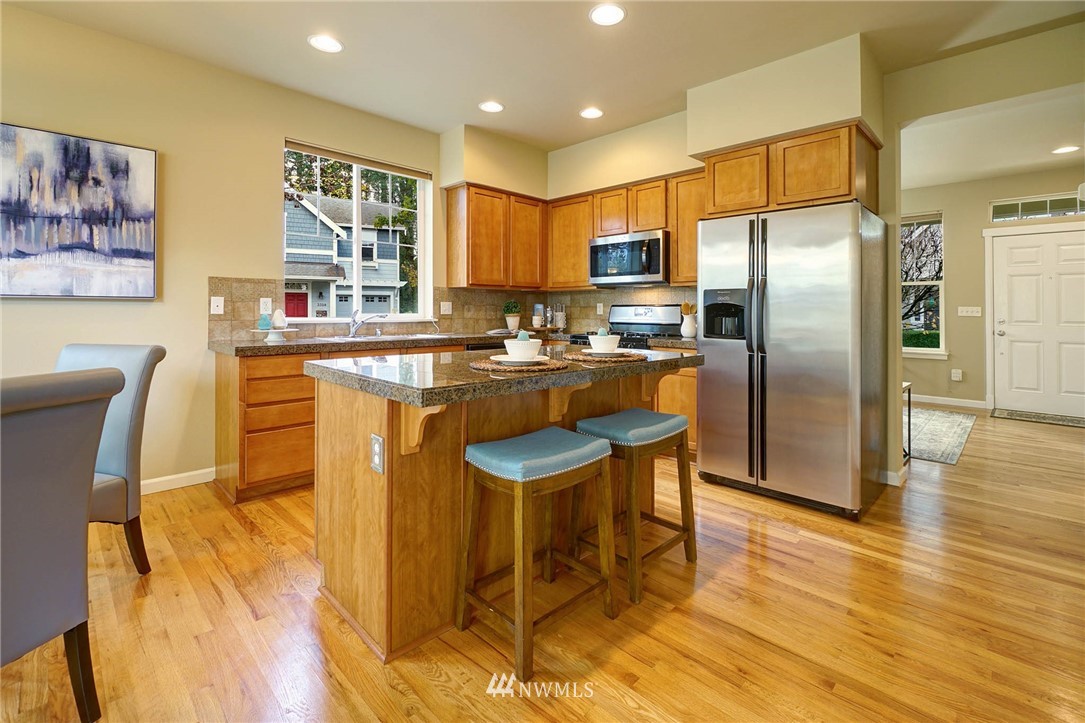 23927 33rd Drive Southeast, Unit 15 Bothell, WA 98021 - Photo 10 of 34 a kitchen with stainless steel appliances granite countertop a sink a stove a refrigerator cabinets and dining table