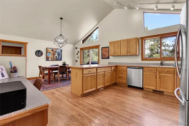 a kitchen with stainless steel appliances kitchen island granite countertop a sink cabinets and wooden floor