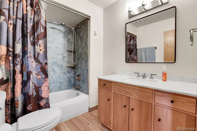 a bathroom with a toilet a bath tub a sink and mirror