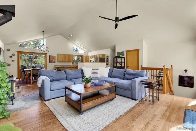 a living room with furniture a ceiling fan and a rug