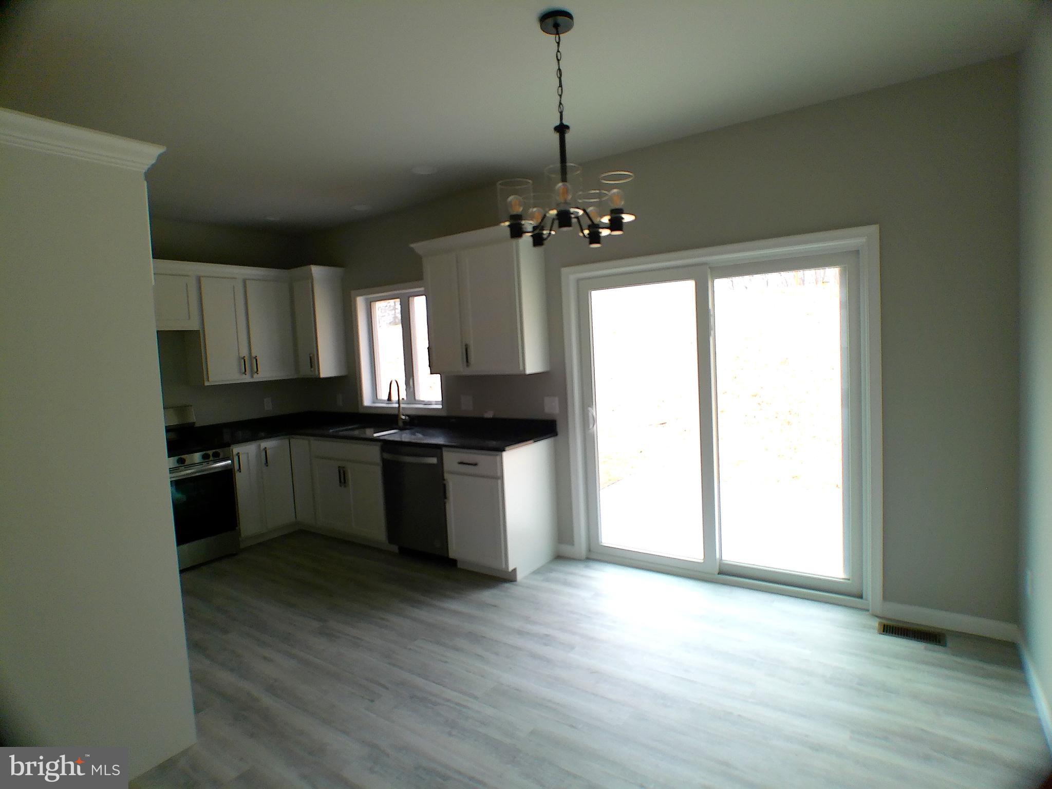 1735 Quarry Road Lebanon, PA 17046 - Photo 5 of 24 a large kitchen with granite countertop stainless steel appliances a window and wooden floor