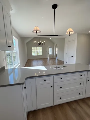 a kitchen with granite countertop a sink a stove and cabinets