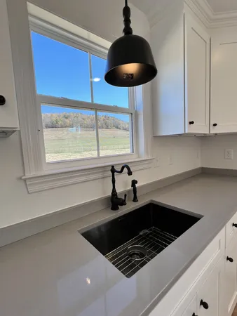 a kitchen with a sink a window and cabinets