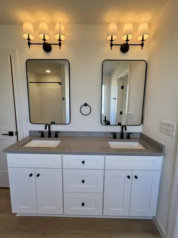 a bathroom with double vanity sinks and a mirror