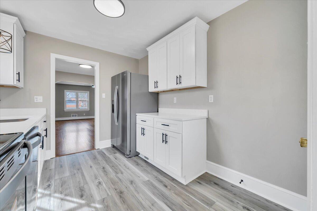 3452 Courtland Road Northwest Roanoke, VA 24012 - Photo 15 of 54 a kitchen with white cabinets and wooden floor