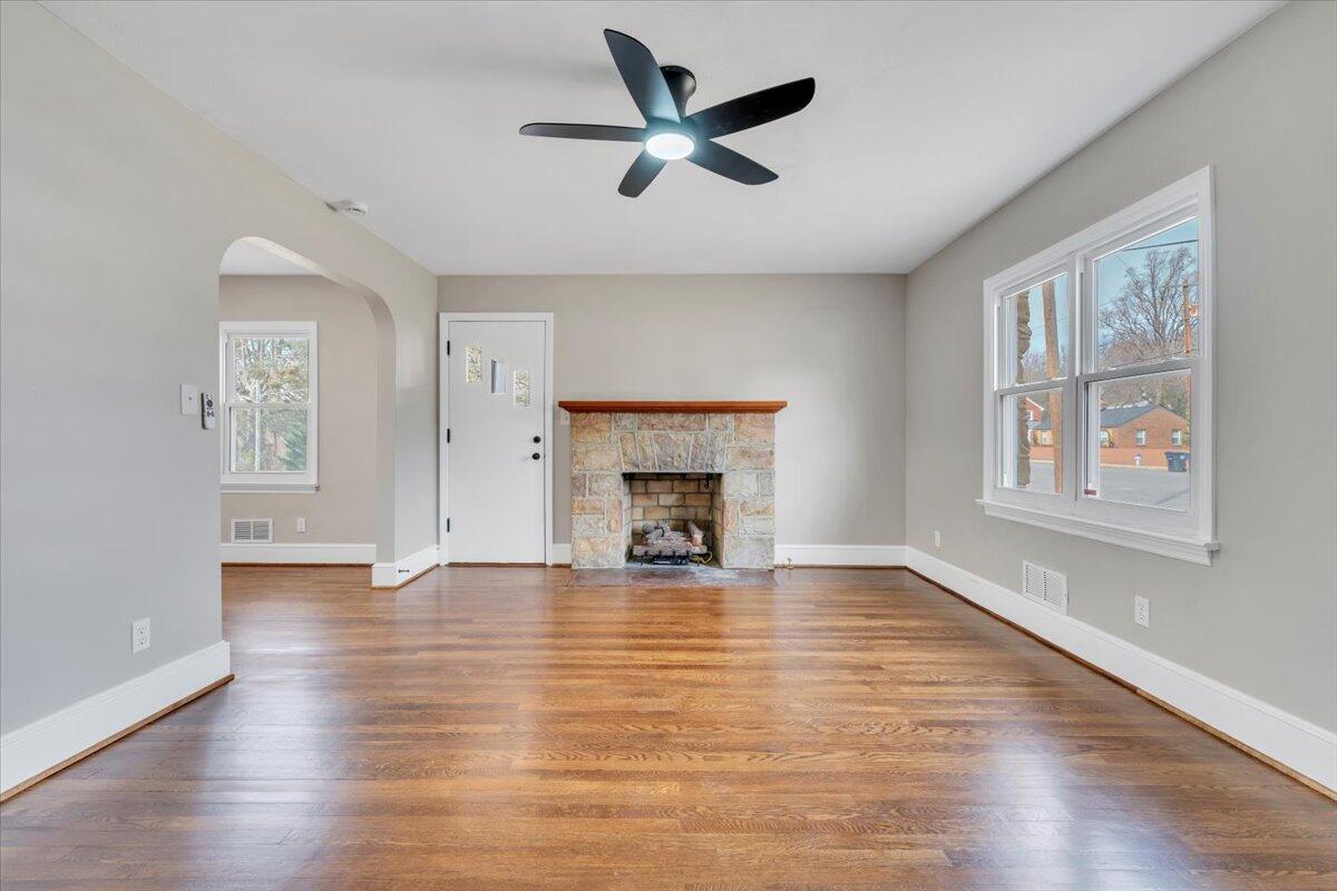 3452 Courtland Road Northwest Roanoke, VA 24012 - Photo 4 of 54 an empty room with windows fireplace and a ceiling fan