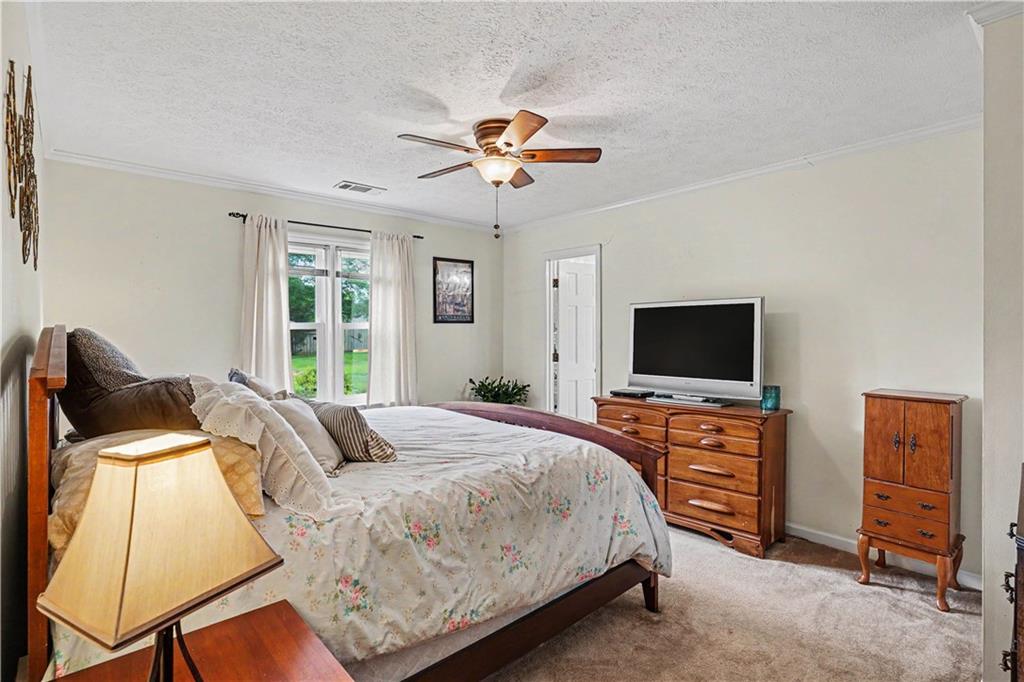 355 Inman Road Hampton, GA 30228 - Photo 10 of 47 a bedroom with a bed and a flat screen tv