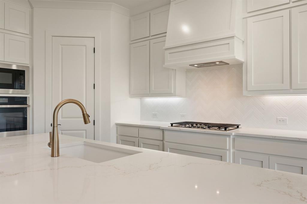 128 Highgate Court Boyd, TX 76023 - Photo 14 of 40 a kitchen with white cabinets and appliances