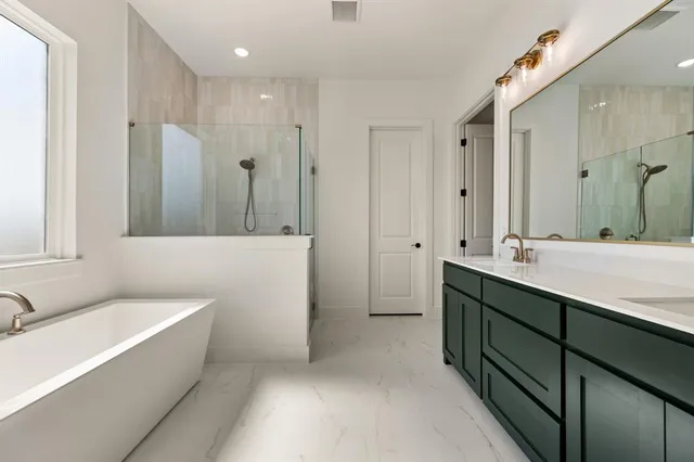 a bathroom with a double vanity sink a mirror and a bathtub