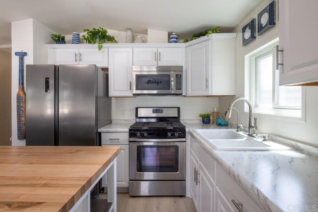 123 Jasper Street Encinitas, CA 92024 - Photo 7 of 15 a kitchen with stainless steel appliances granite countertop a sink stove and refrigerator