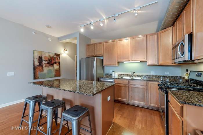 1200 West Monroe Street, Unit 502 Chicago, IL 60607 - Photo 7 of 20 a kitchen with stainless steel appliances granite countertop a stove a sink and a microwave