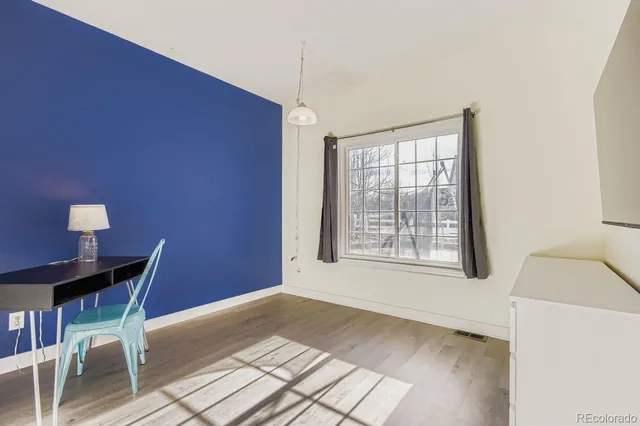 a spacious bedroom with a bed a dresser and a large window