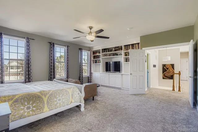 a spacious bedroom with a bed and a chandelier