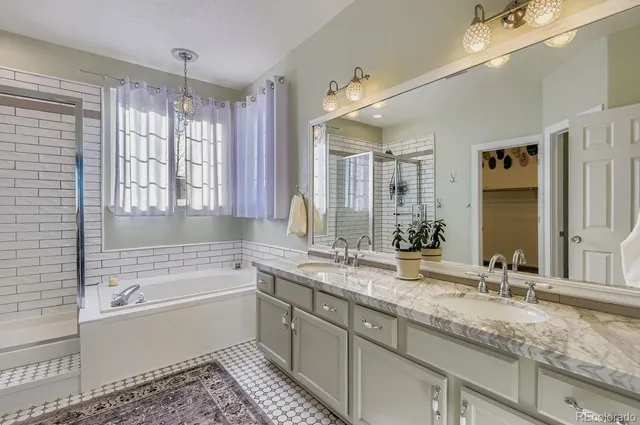 a bathroom with a granite countertop bathtub a sink and a shower