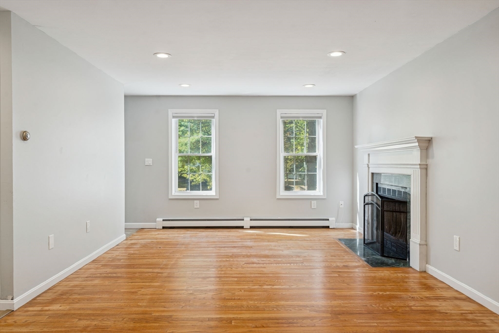 16 Captain Danforth Lane Amherst, NH 03031 - Photo 14 of 30 an empty room with wooden floor and fireplace