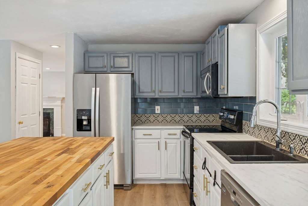 16 Captain Danforth Lane Amherst, NH 03031 - Photo 7 of 30 a kitchen with stainless steel appliances granite countertop a refrigerator sink and cabinets